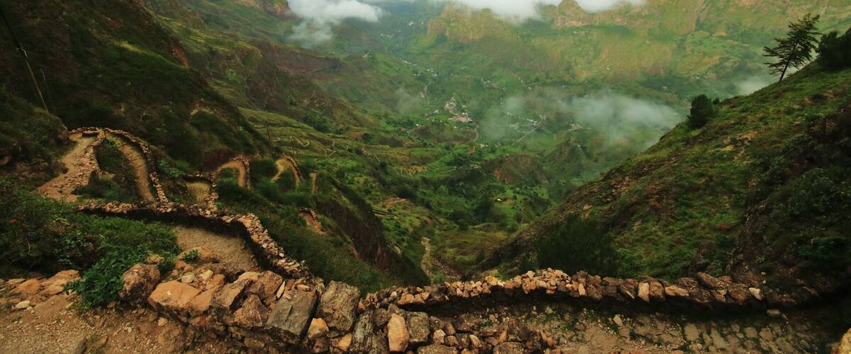 A mountainous landscape with terraced fields and a stone pathway.