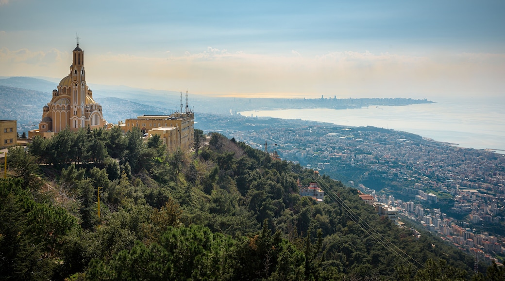Our Lady of Lebanon Maronite church sits on a hill over the Jounieh bay, with Beirut capital city in the background, in Lebanon, Middle East