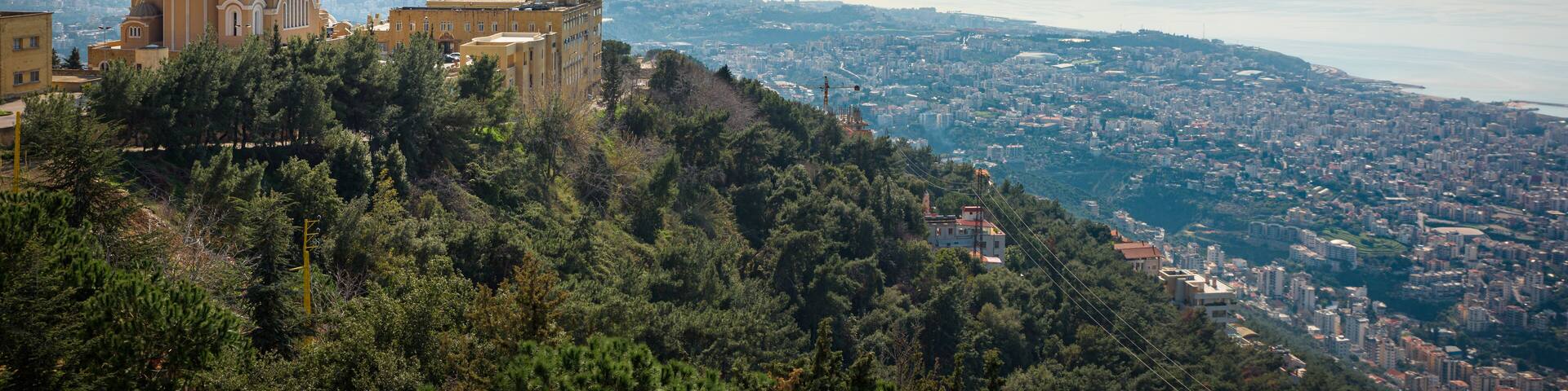 Our Lady of Lebanon Maronite church sits on a hill over the Jounieh bay, with Beirut capital city in the background, in Lebanon, Middle East