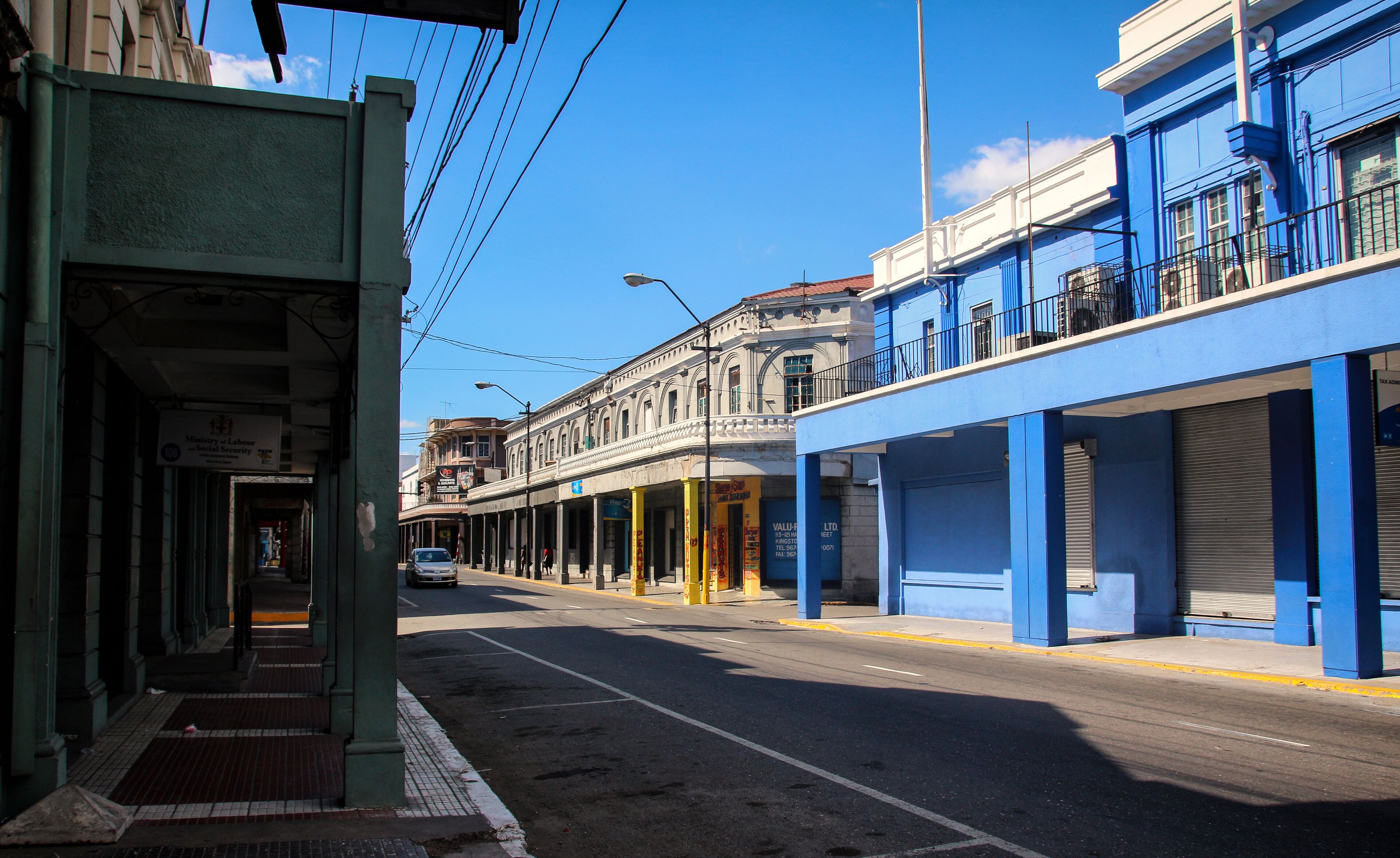 A street with buildings, a sidewalk, and a car.