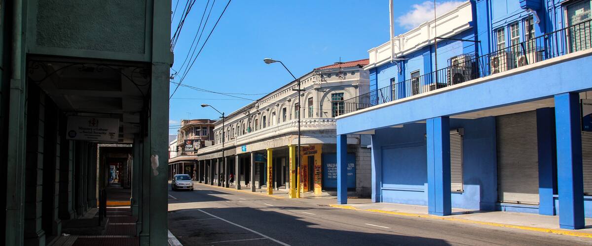 A street with buildings, a sidewalk, and a car.