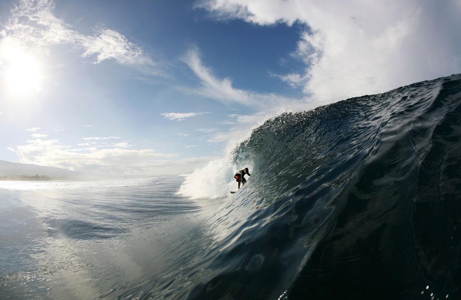 A surfer enters a barrel wave at Maninoa, Upolu, Samoa.