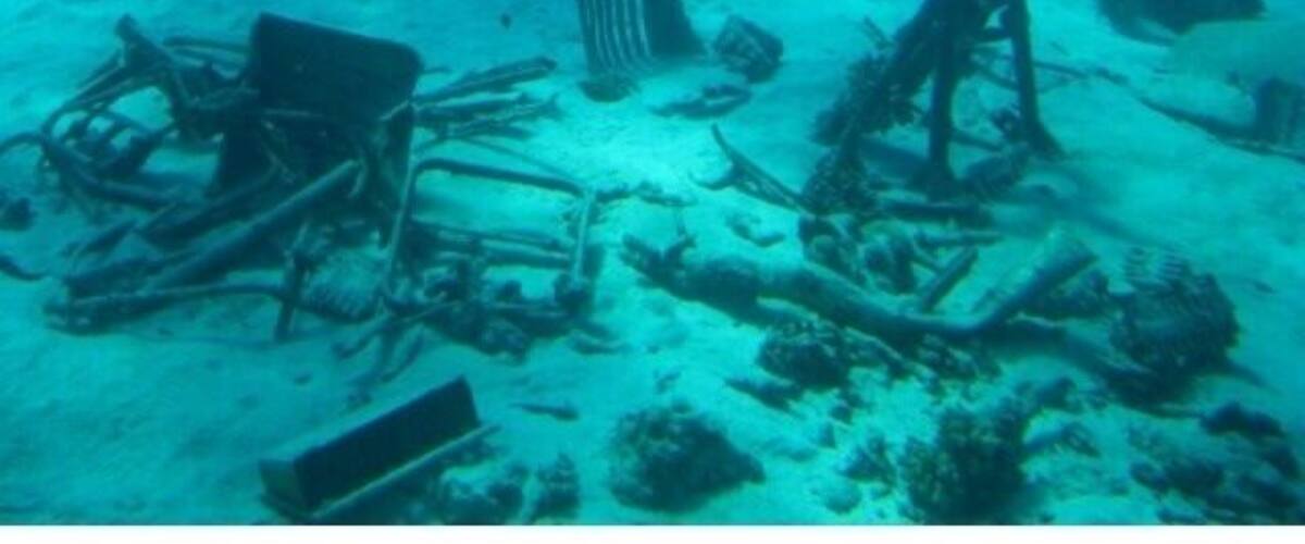 An underwater scene with scattered debris and a large shark.