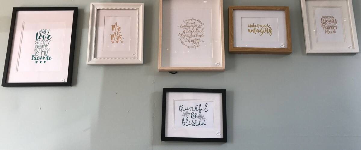Six framed inspirational quotes on a wall.