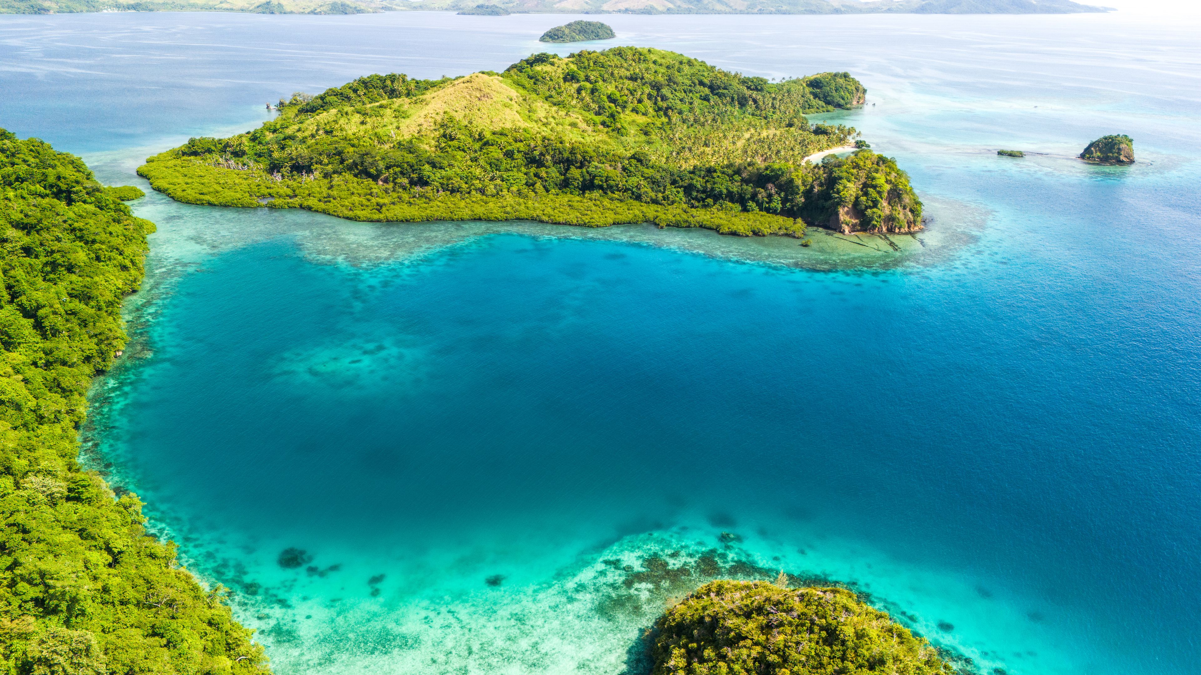 Une île tropicale entourée d’eaux turquoise et cristallines.