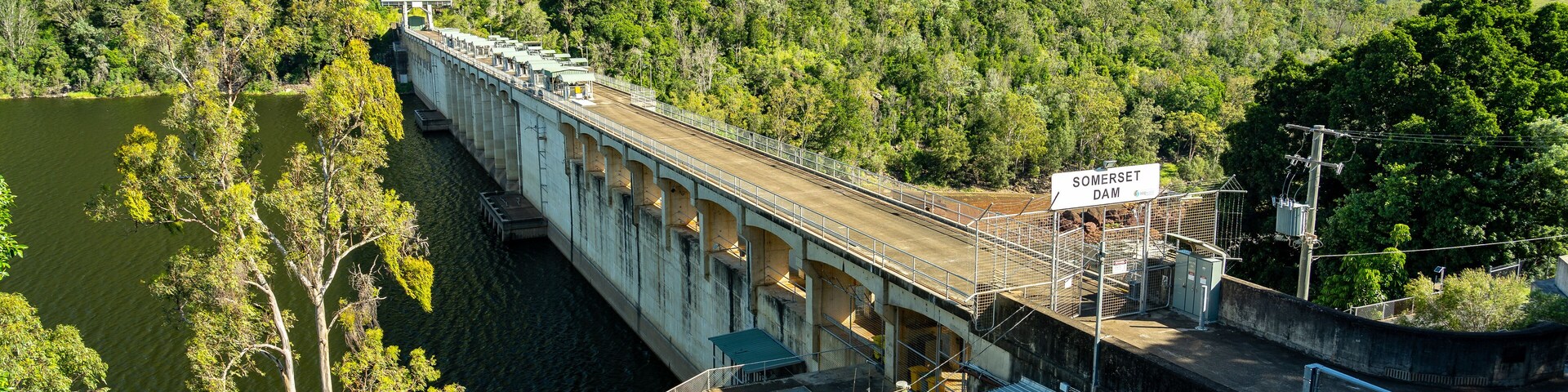 Una presa con un puente, rodeada de colinas boscosas.