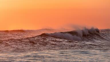 waves breaking at sunset creating spray
