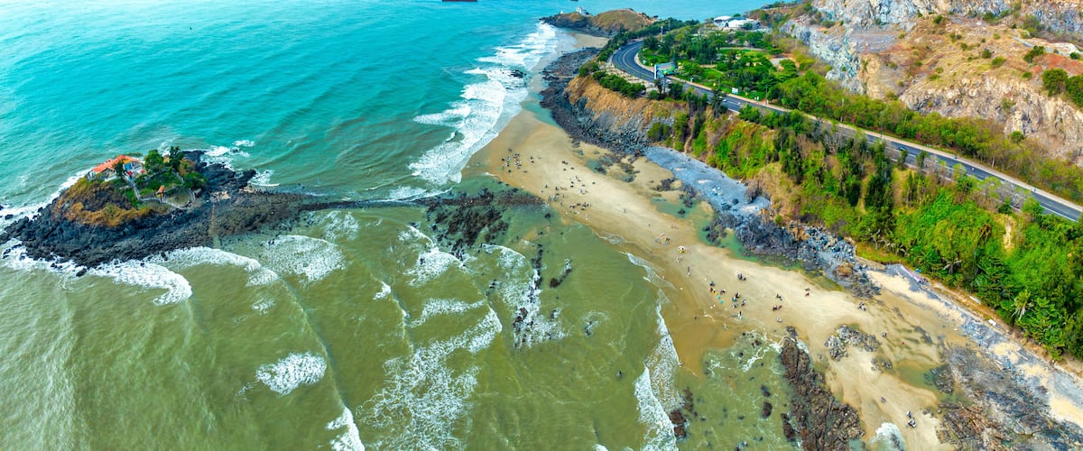 Aerial view of Hon Ba island in Vung Tau city, Vietnam. On full moon day of lunar calendar, when tide is low, people can walk across island to visit temple on mountain. Spiritual travel concept.