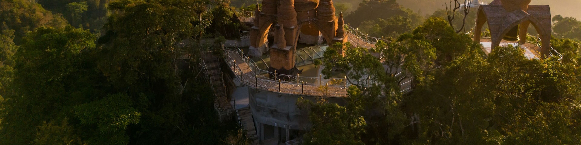 Beautiful sunrise with pagodas on the top of cliff, morning mist at Khao Na Nai Luang Dharma Park, Surat Thani province, Thailand