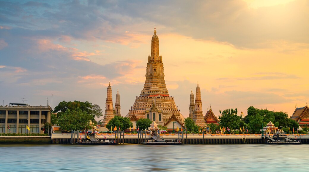 A temple complex with multiple spires and intricate architecture, situated by a calm river.