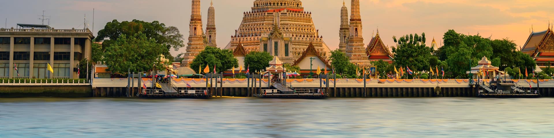 A temple complex with multiple spires and intricate architecture, situated by a calm river.