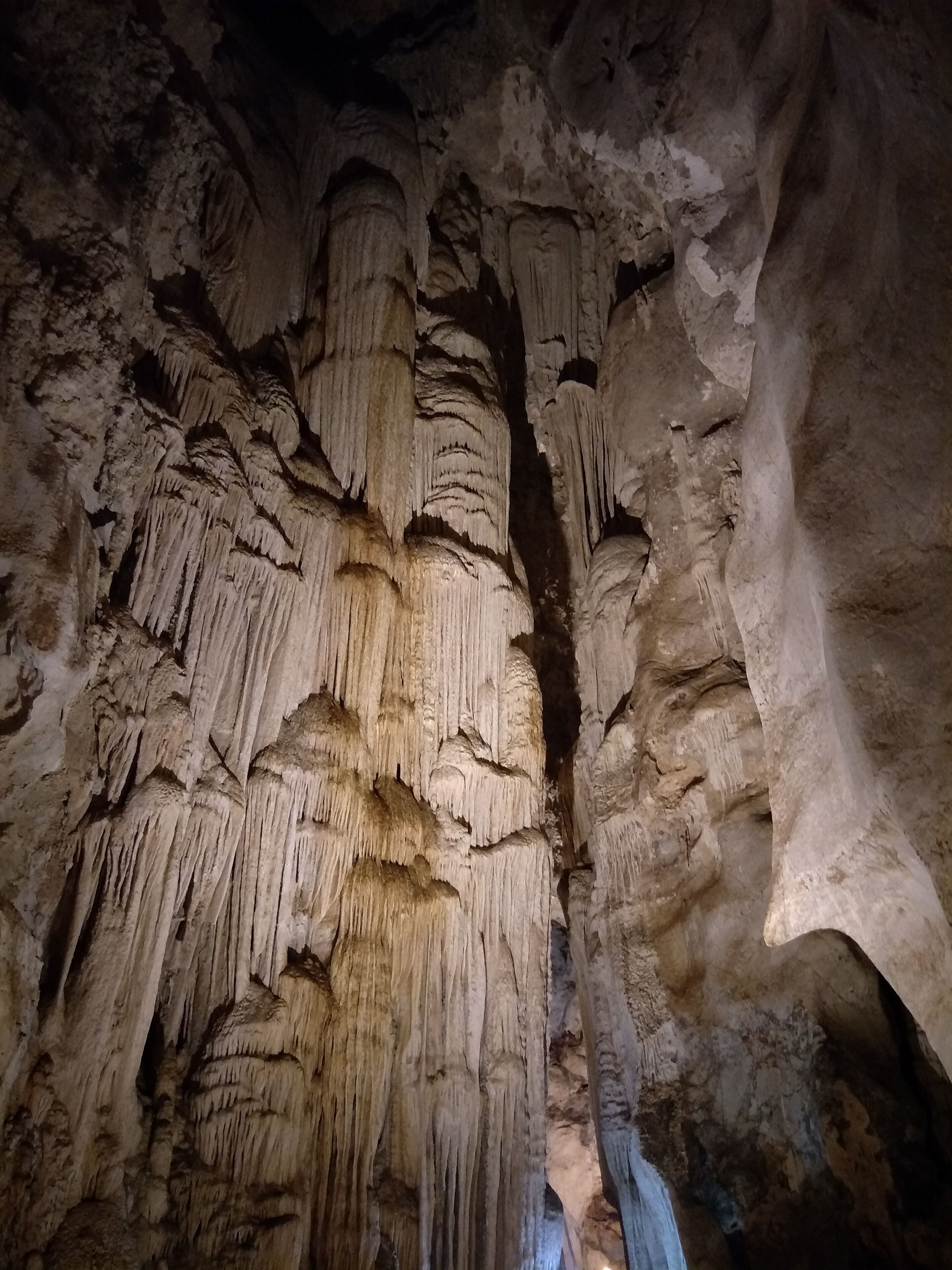 A cave with stalactites hanging from the ceiling and stalagmites rising from the ground.