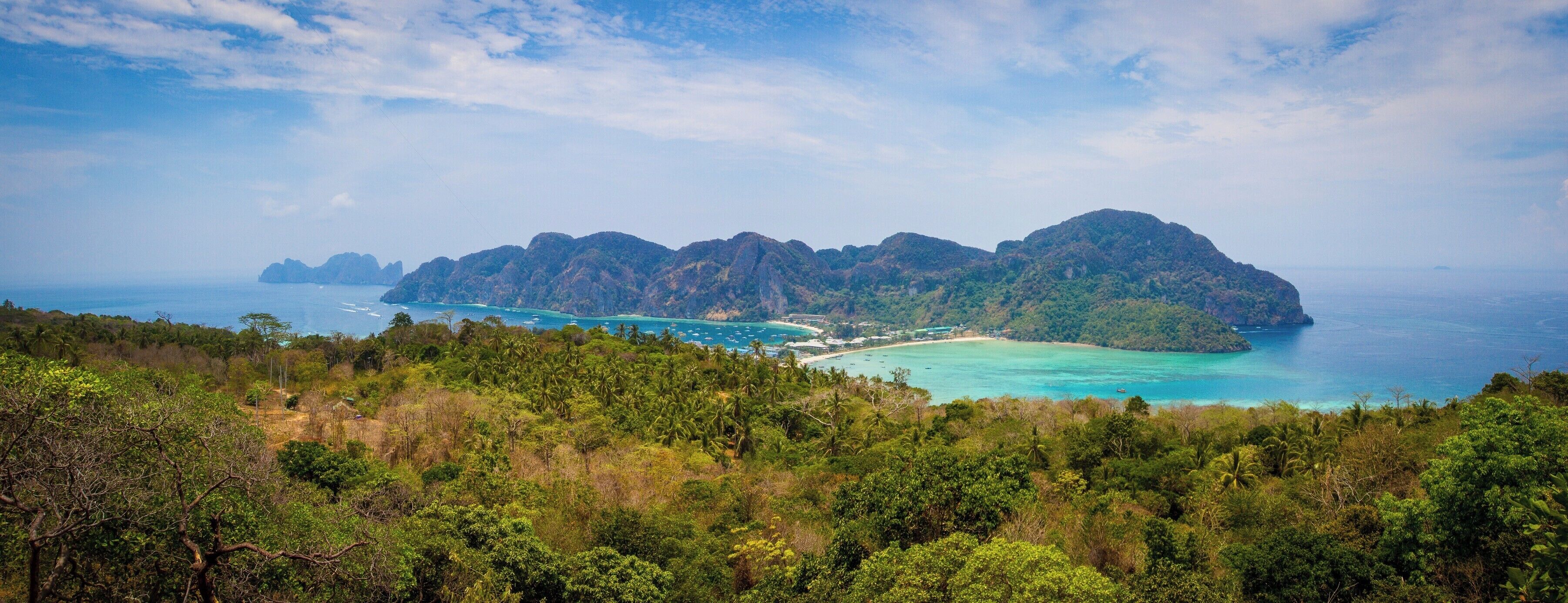 A tropical island with lush greenery, clear turquoise waters, and a small beach.