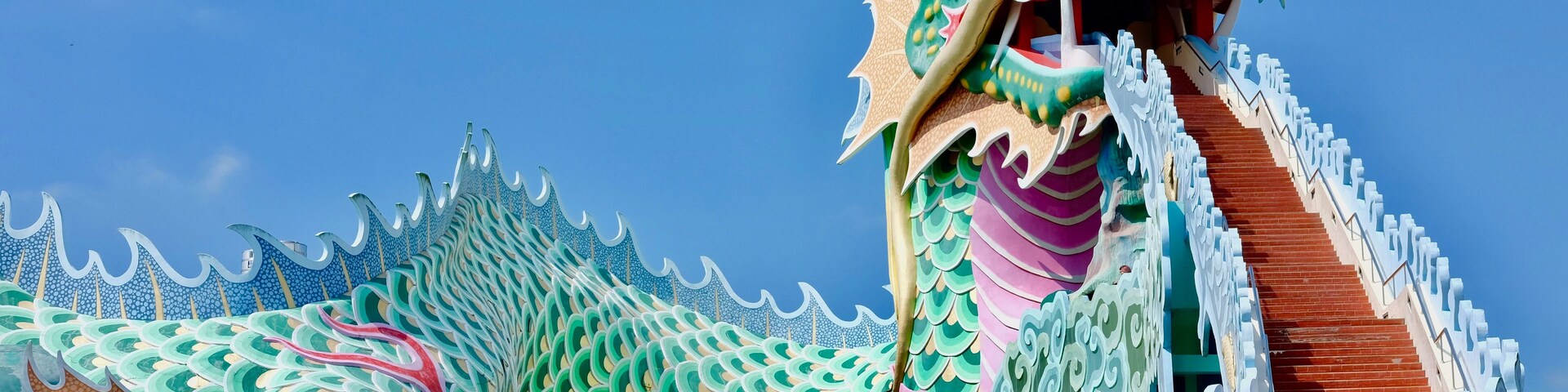 Uma grande escultura de dragão com uma escadaria que leva até ela.