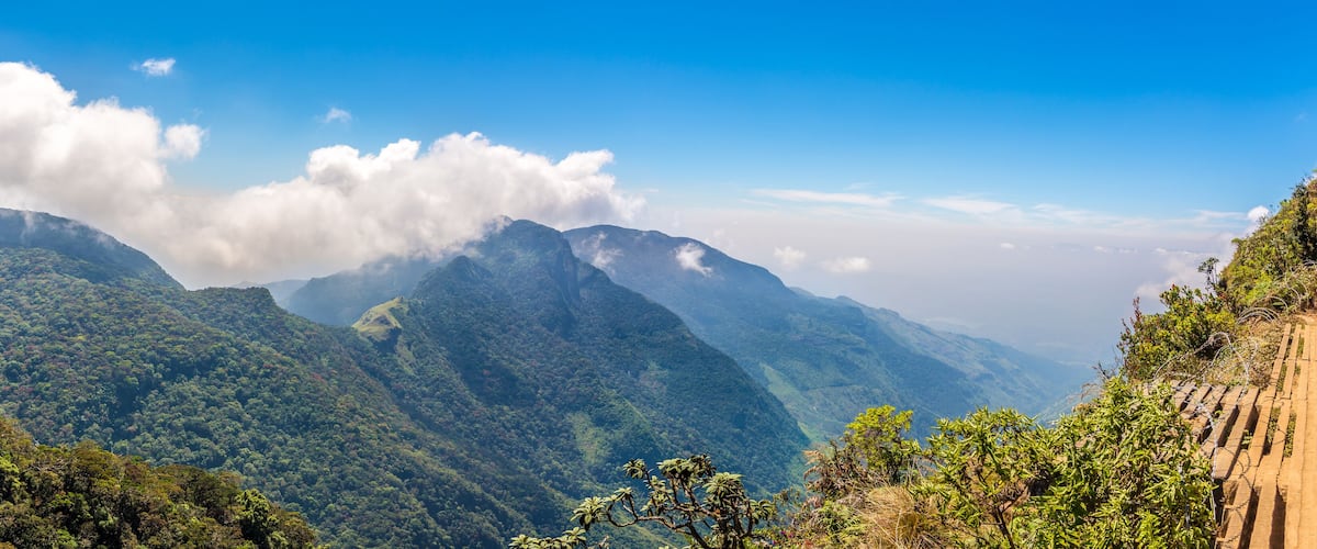 A mountainous landscape with lush greenery and a clear blue sky.