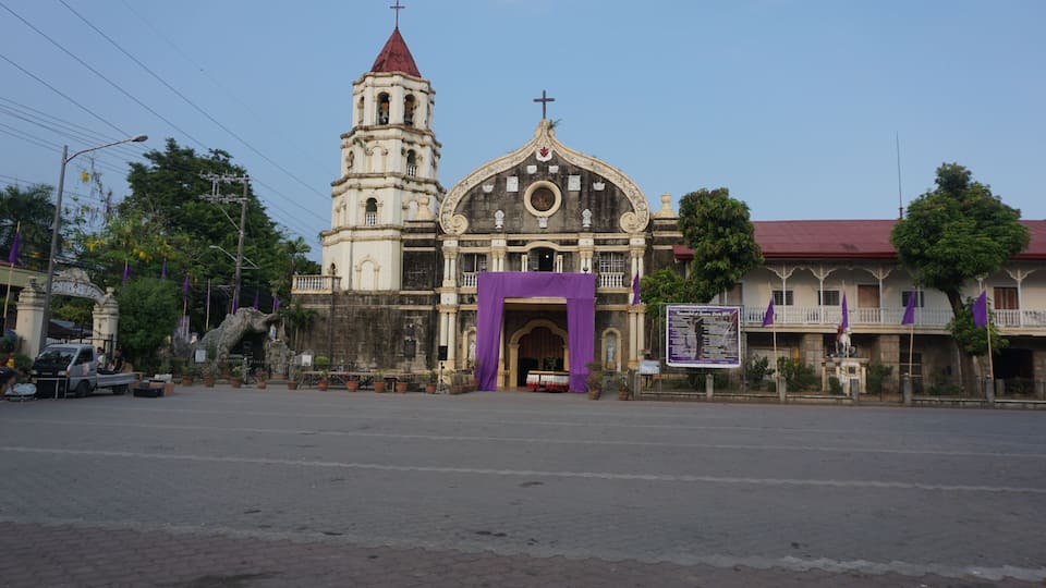 A historic church with a bell tower and a large archway.