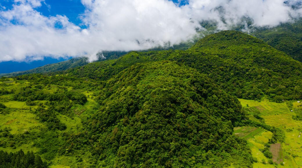 Aerial drone view of clouds over rural farmland and Mount Mambajao on Camiguin island, Philippines