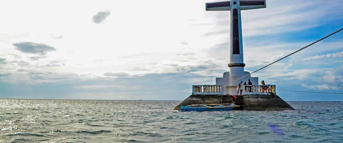 Una gran cruz sobre una base de concreto rodeada de agua.