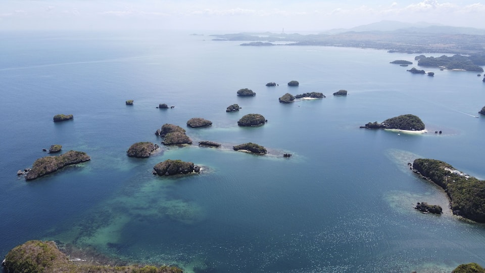 A coastal landscape with numerous small islands surrounded by clear blue waters.