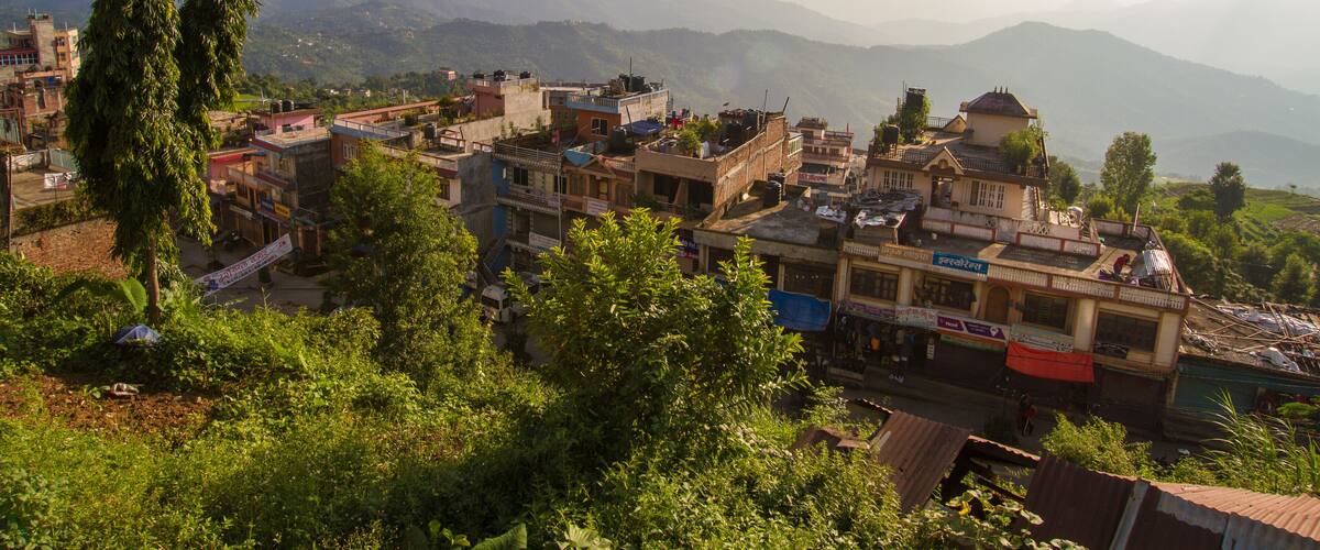 A mountainous village with traditional buildings and lush greenery.