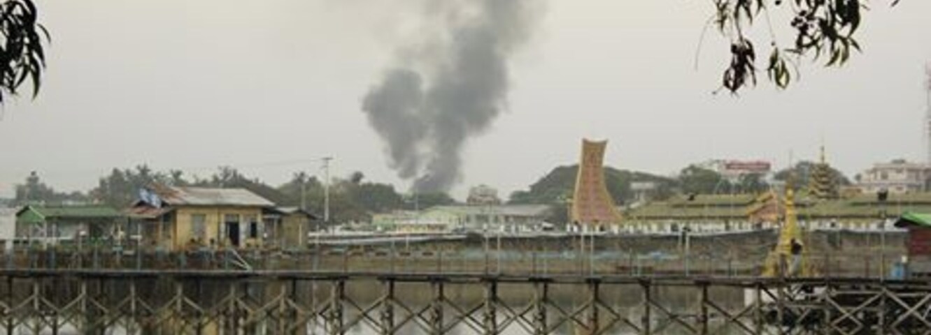 Massa de água com uma ponte e edifícios ao fundo.