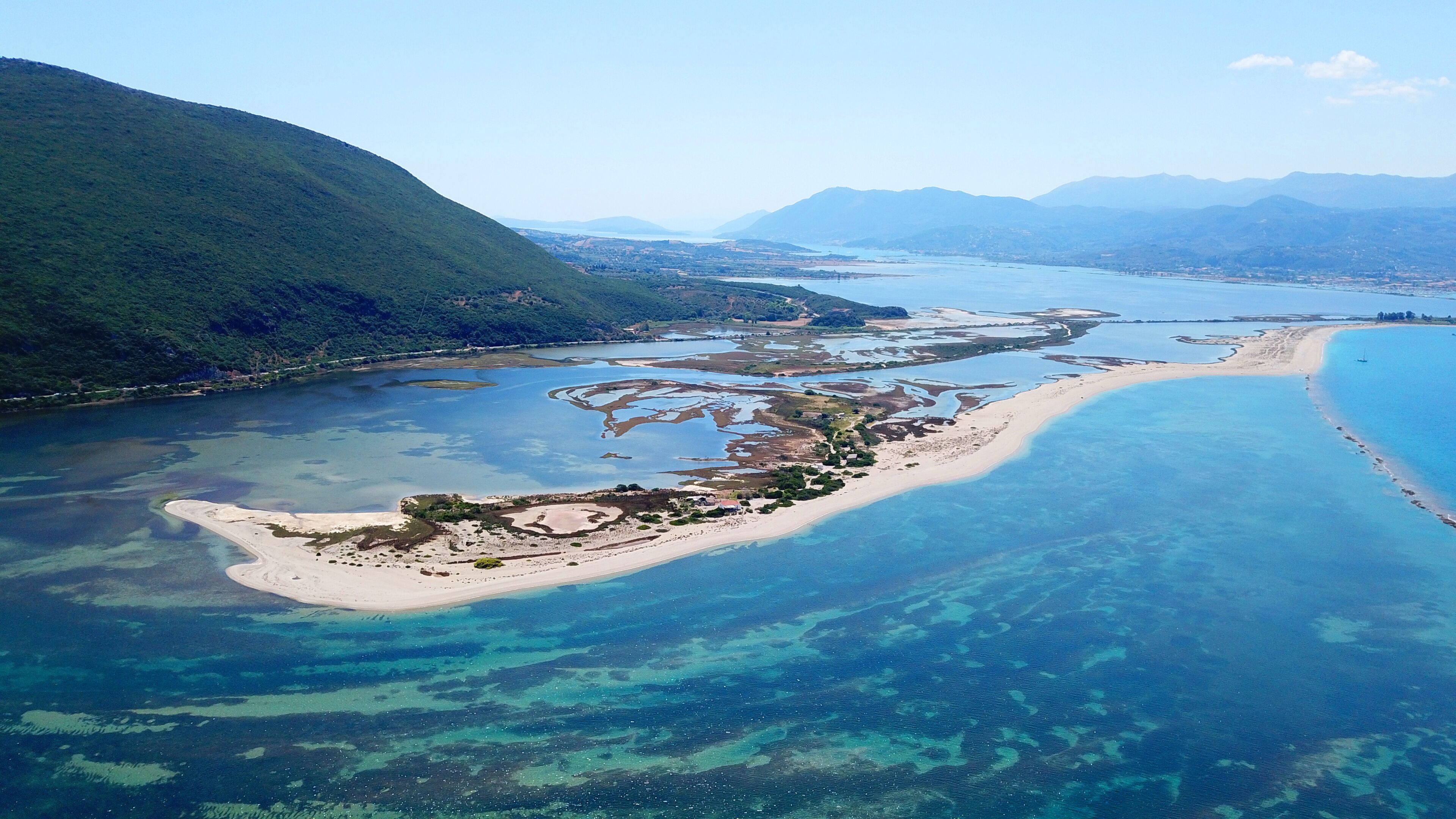 Aerial drone bird's eye view photo of tropical and exotic coral reef forming an atoll archipelago with beautiful sapphire and turquoise open ocean