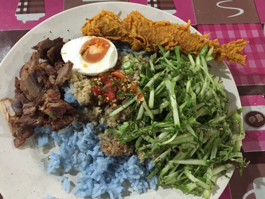 If you are a tourist or just feeling like wanting to try something unique go for this salad rice (Nasi Kerabu). Mix all the ingredients well preferably with hands. Eating with your hand is the norm here. Steal a glance and see how the locals did it.