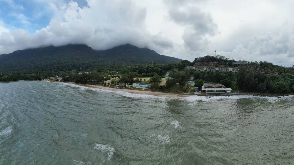 A coastal island with a mountain in the background, surrounded by water.