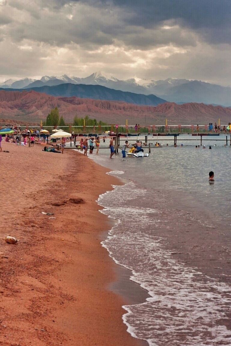 August 2013
Kaji Say, Issyk-kul Lake, Kyrgyzstan
Issyk Kul is an endorheic (i.e. inflow only) lake in eastern Kyrgyzstan. It is the tenth largest lake in the world by volume (though not in surface area), and the second largest saline lake after the Caspian Sea and the second largest mountain lake after Titicaca. Although it is surrounded by snowy peaks, it never freezes hence its name, which means "hot lake" in the Kyrgyz language. It is some 180 km long and 60 km wide, up to 600 meters deep and located in altitude ca. 1.600 meters, very popular for recreation, mainly in resorts on its north shore. Kaji Say is on south shore and more calm and relaxed place. The mountains in picture are Terskey Alatau range of Northern Tian Shan. The lake has some 20 percent salinity compared to oceans. However an ocean for Kyrgyz for sure.