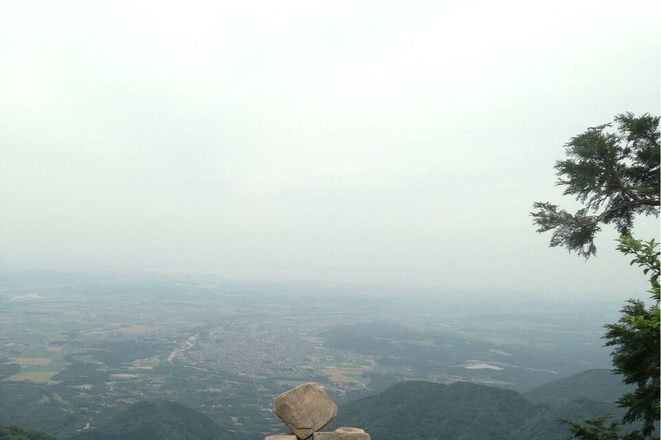 Una sporgenza rocciosa con una struttura di pietra bilanciata in un paesaggio montano.