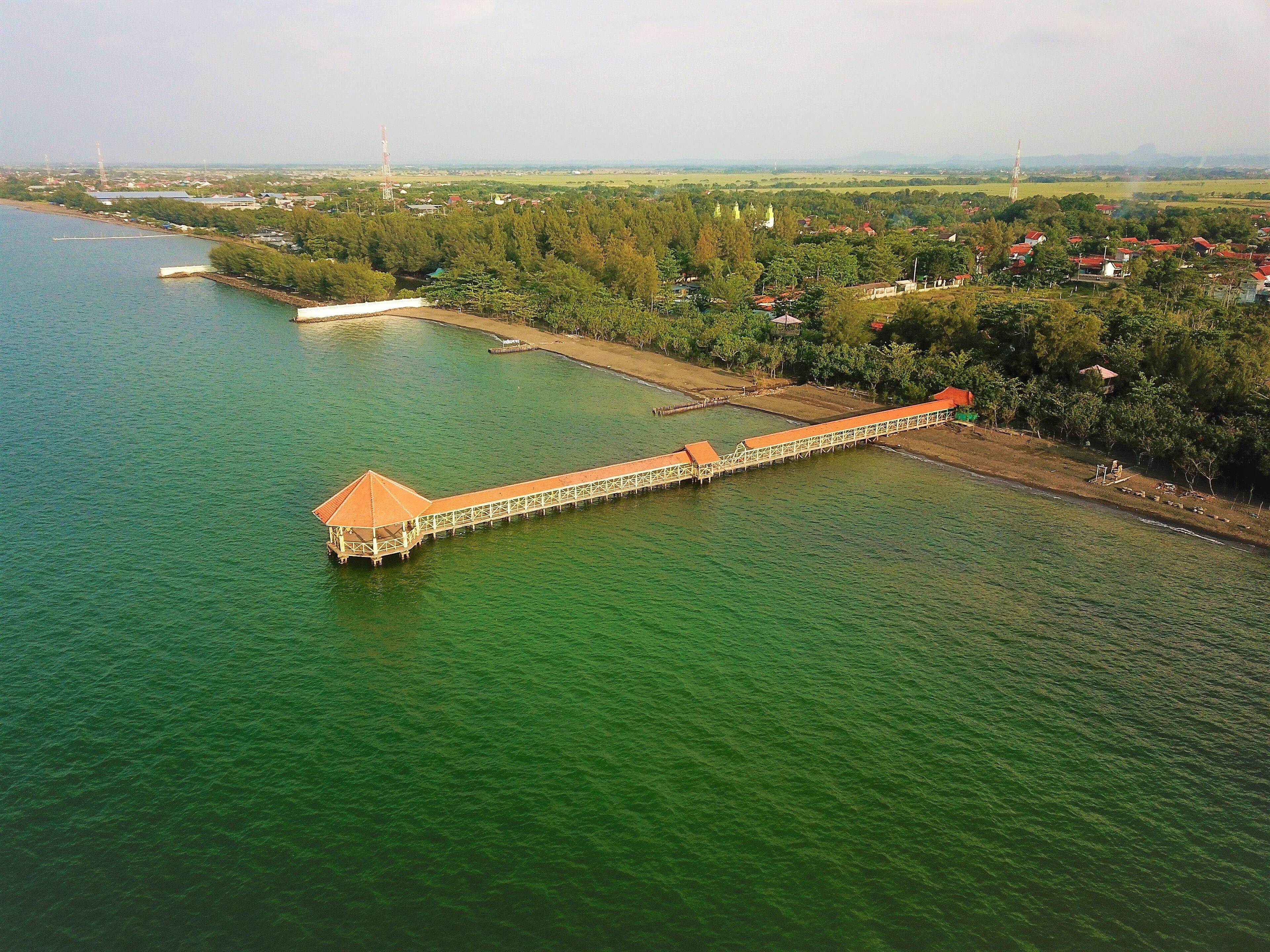 A long bridge over a river with a small island on the left.