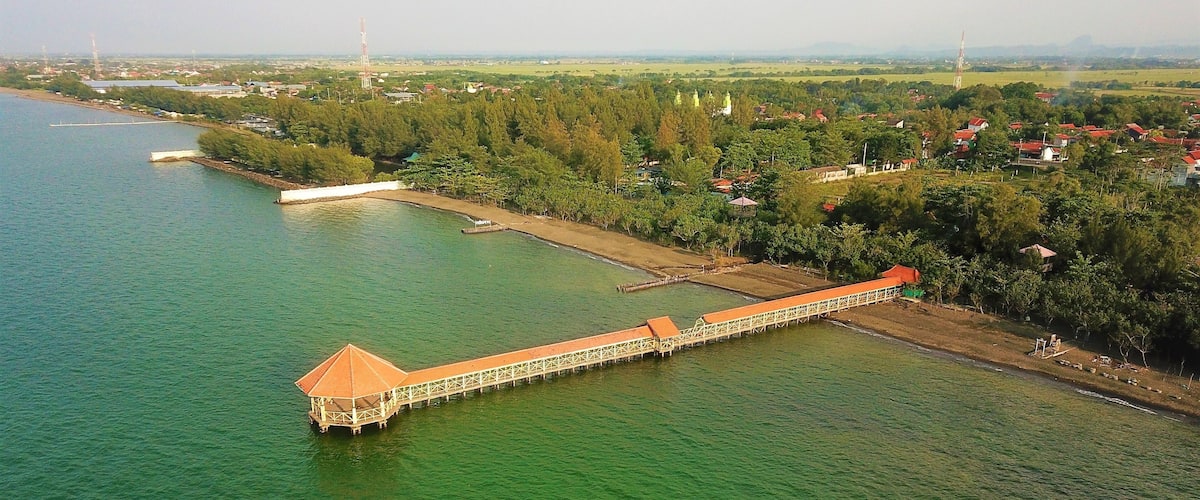 A long bridge over a river with a small island on the left.