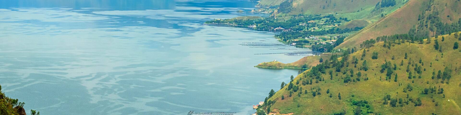 Panoramic aerial drone view of Toba Lake with blue water at Pangururan in Samosir Island, Sumatra Utara, Indonesia