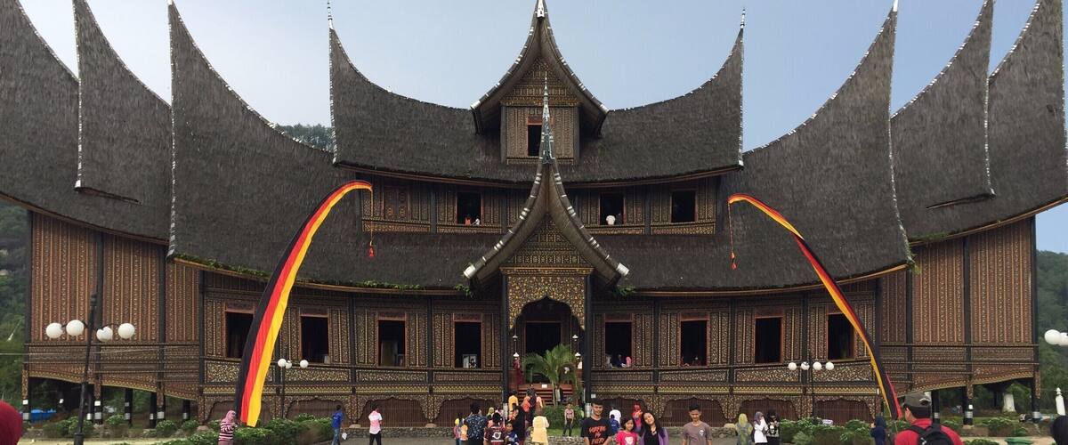 A traditional wooden building with multiple pointed roofs and a central entrance.