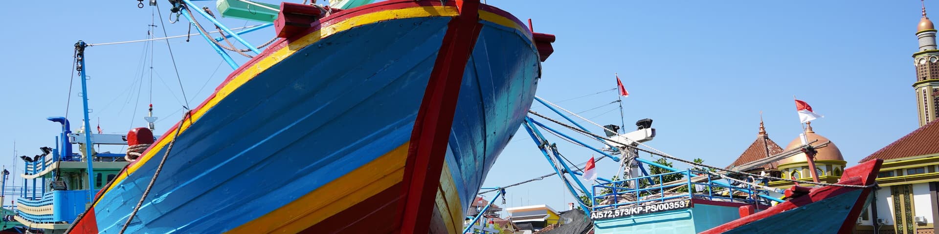 A wooden fishing boat is parked at the mouth of the Juwana River, Pati, Central Java, Indonesia.