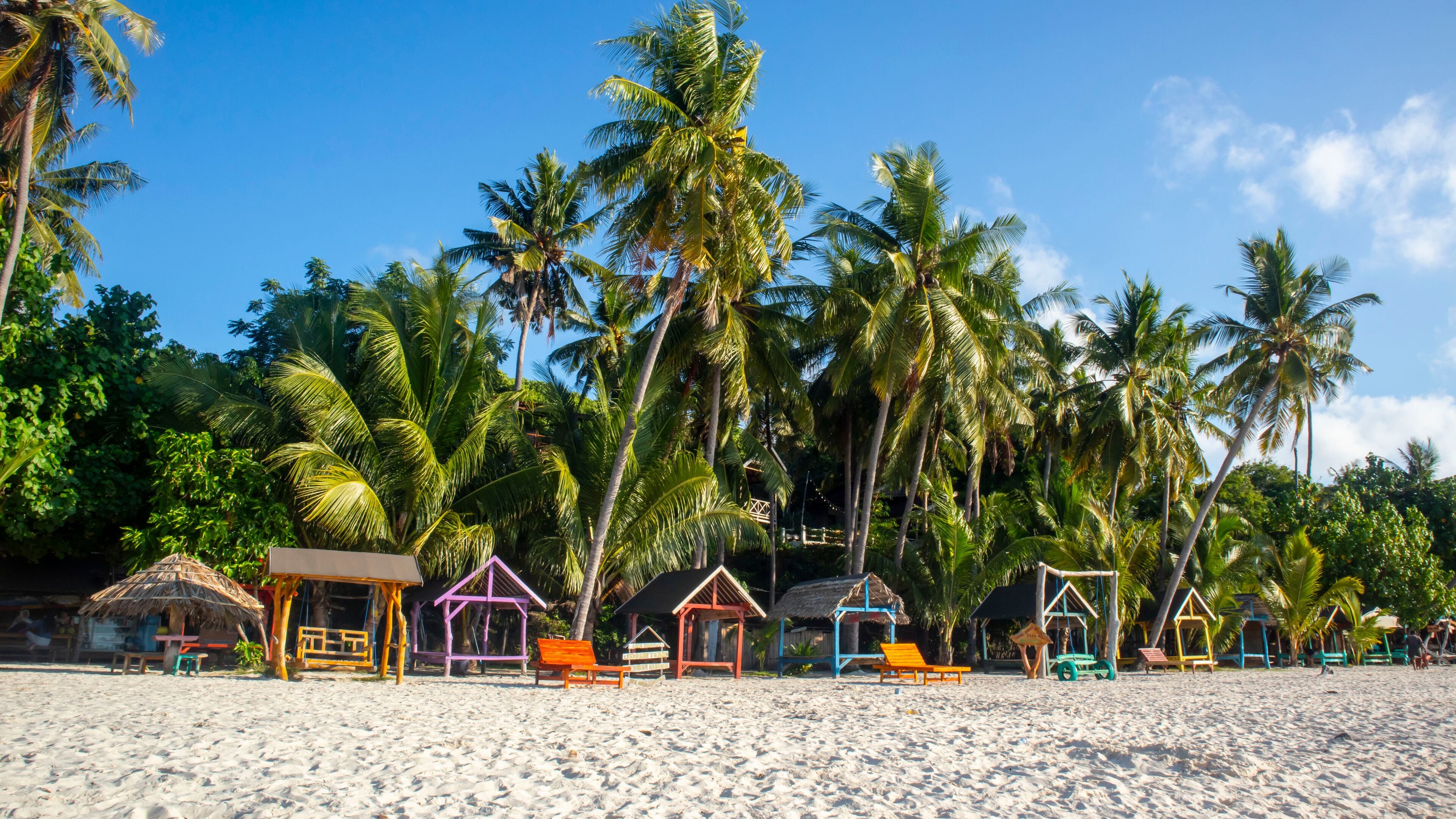 tropical beach with coconut palm trees and blue sky at Bara beach, Bira Bay