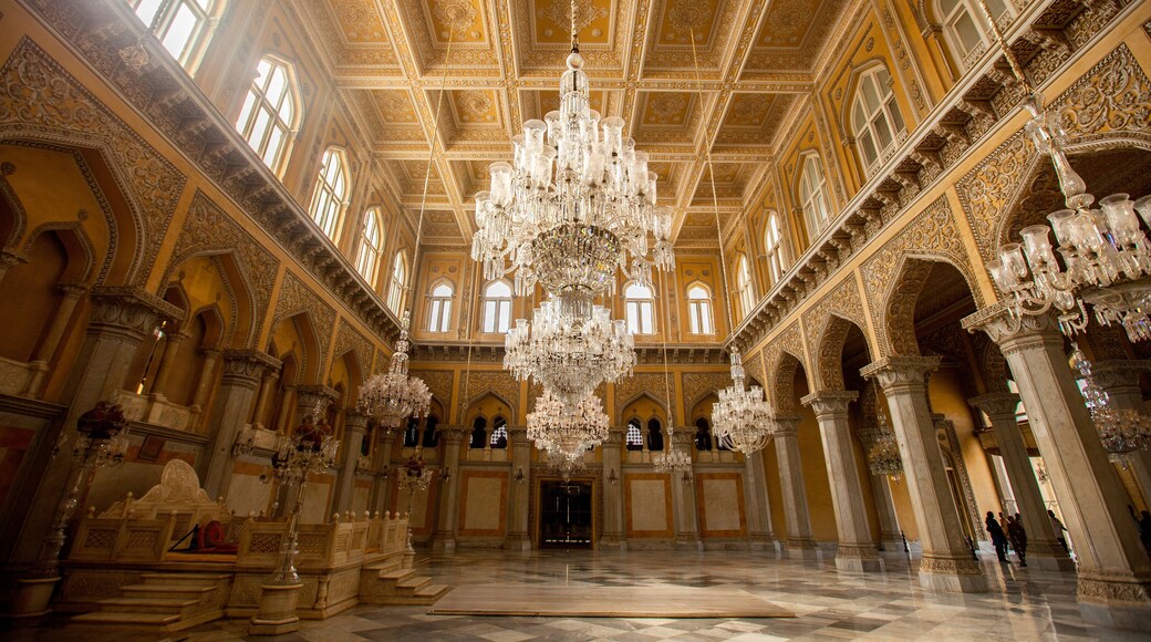 Una sala decorata con un grande lampadario, elaborate decorazioni al soffitto e architettura classica.