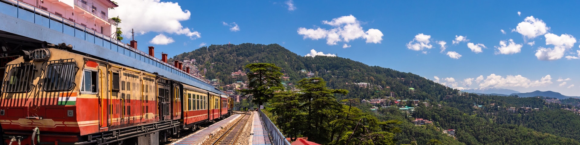 A train on tracks with a mountainous landscape in the background.