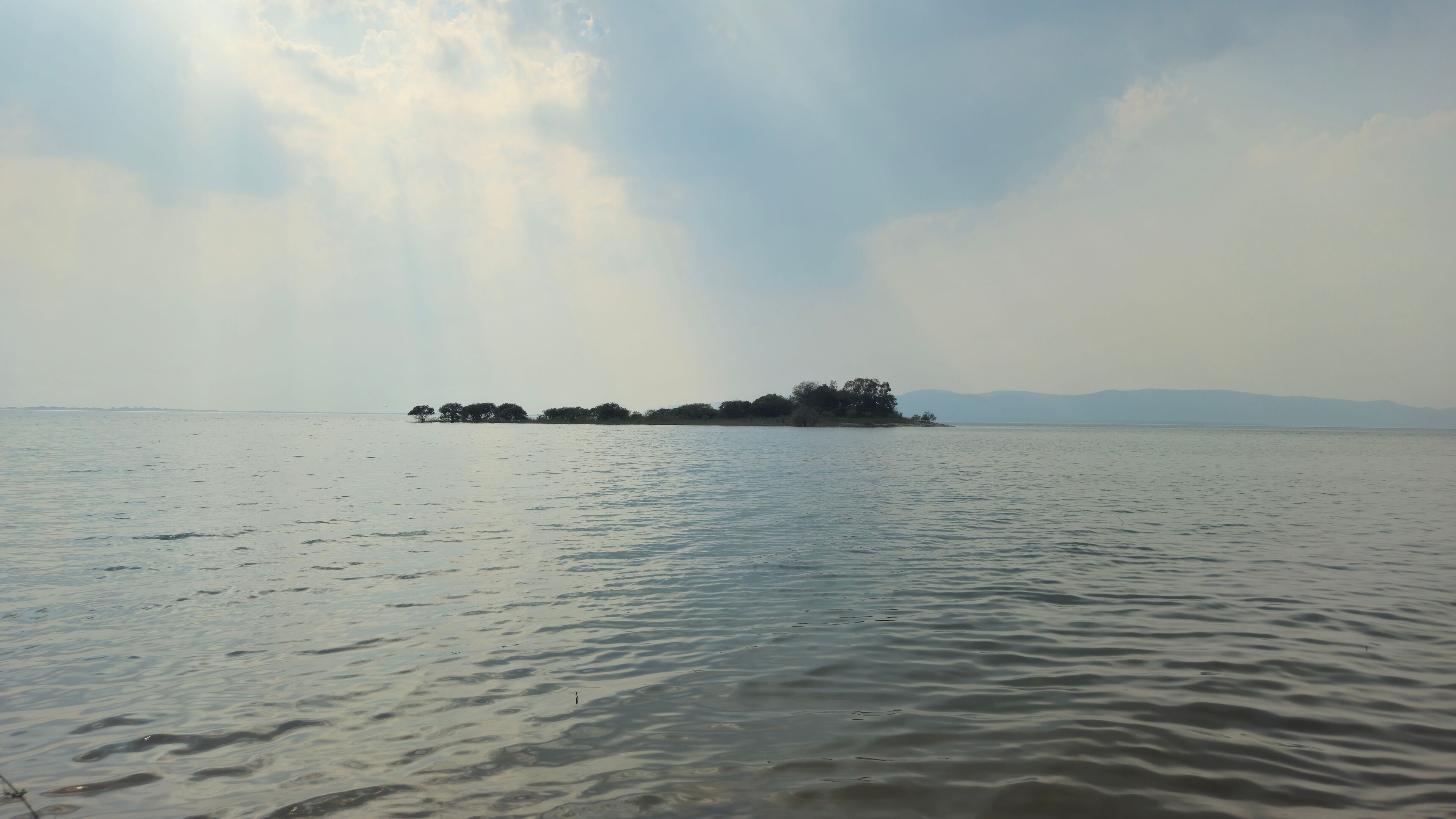 A calm body of water with a small island in the distance.