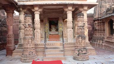 A temple entrance with intricate carvings and a red carpet.