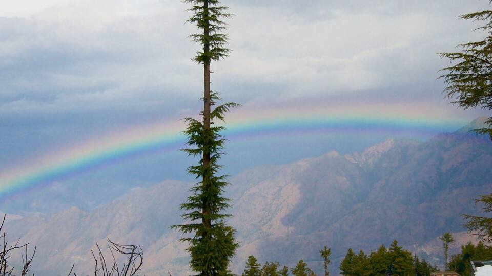 A mountain range with a rainbow arching across the sky.