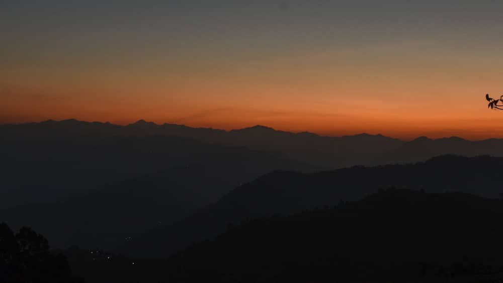 A mountain range silhouetted against a sunset sky.