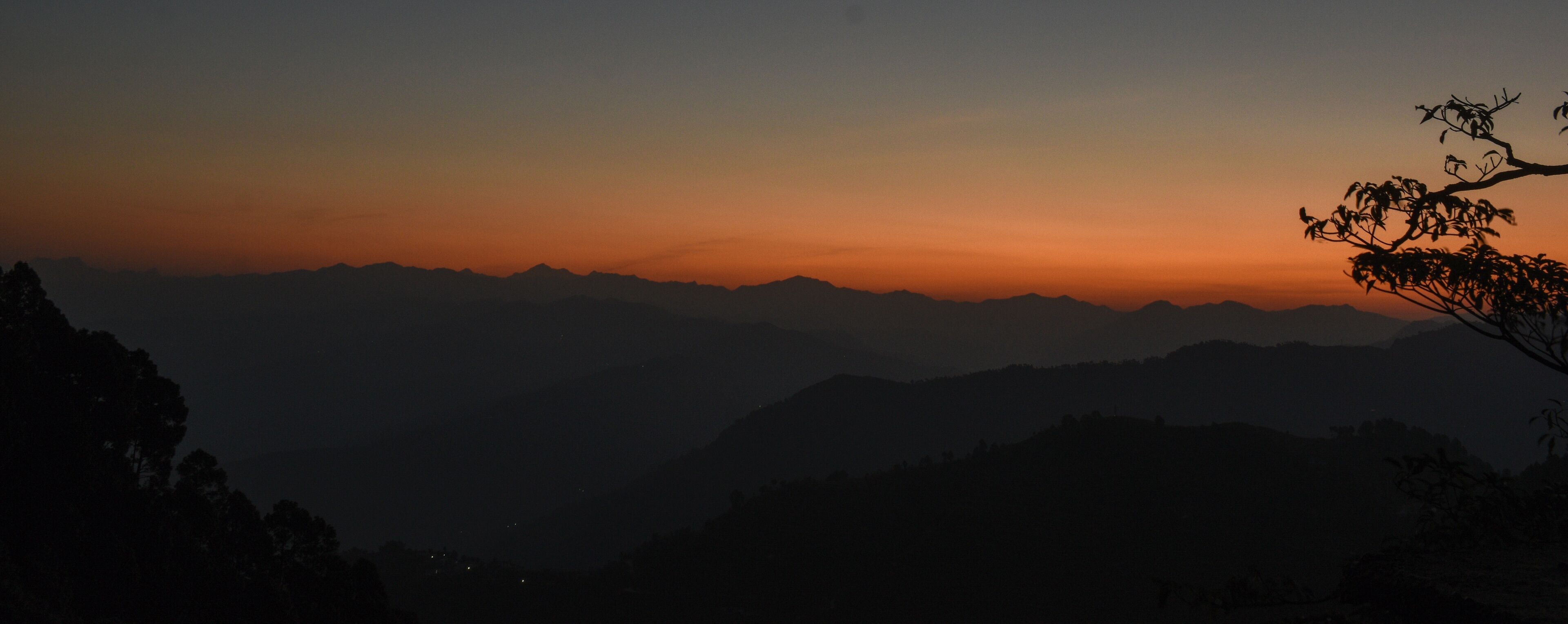 A mountain range silhouetted against a sunset sky.