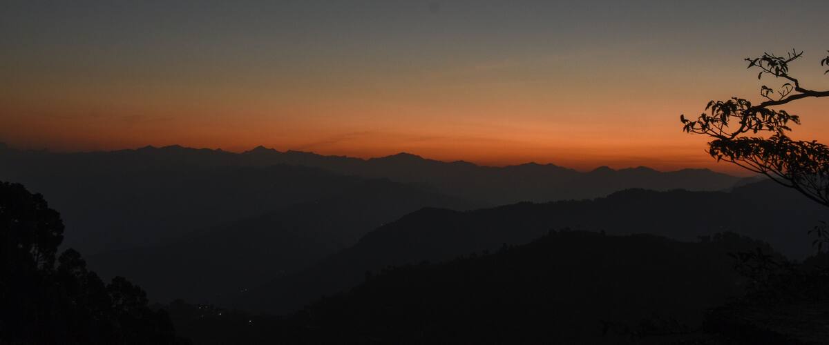 A mountain range silhouetted against a sunset sky.