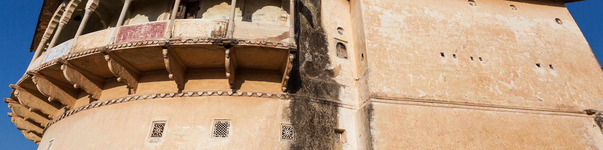 Um edifício histórico com janelas em arco e uma varanda.