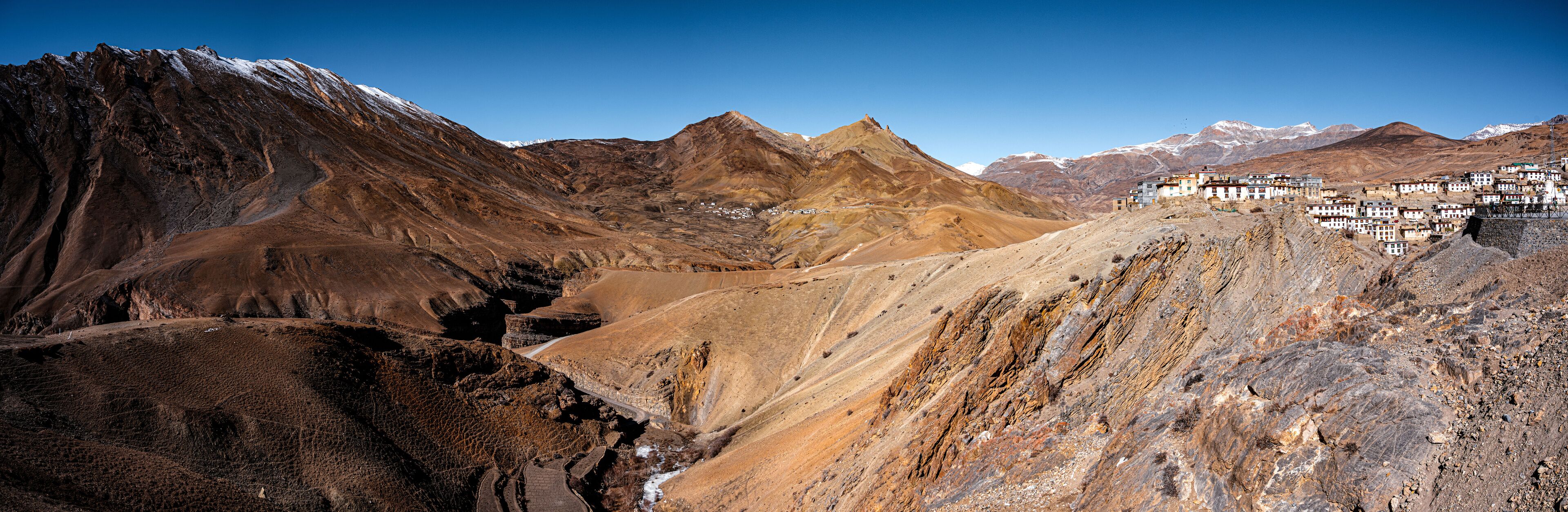 A mountainous landscape with a village nestled in the valley.