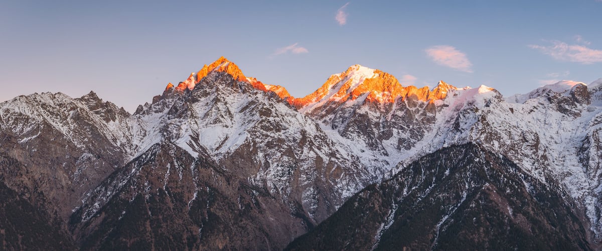 Panoramic view during sunset over snow cladded Kinner kailash mountain peaks falls in Greater Himalayas mountain range from Kalpa village, Kinnaur, Himachal Pradesh, India.