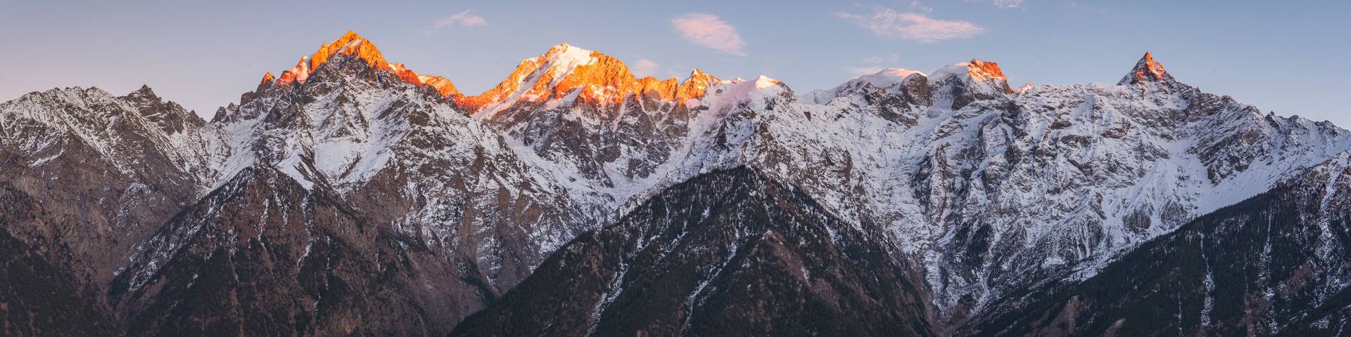 Panoramic view during sunset over snow cladded Kinner kailash mountain peaks falls in Greater Himalayas mountain range from Kalpa village, Kinnaur, Himachal Pradesh, India.