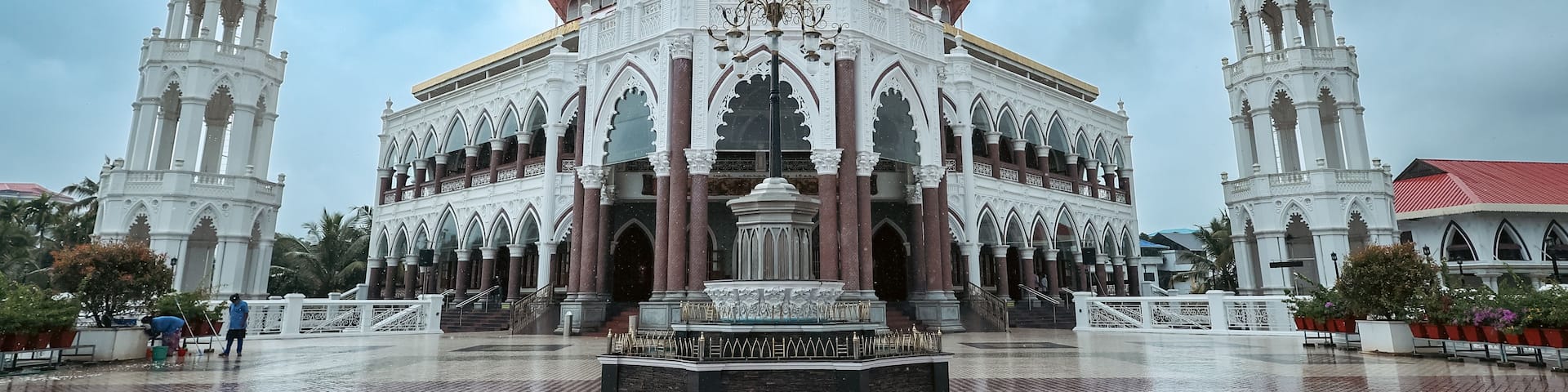 A grand cathedral with intricate architecture, a central statue, and two smaller statues on either side.