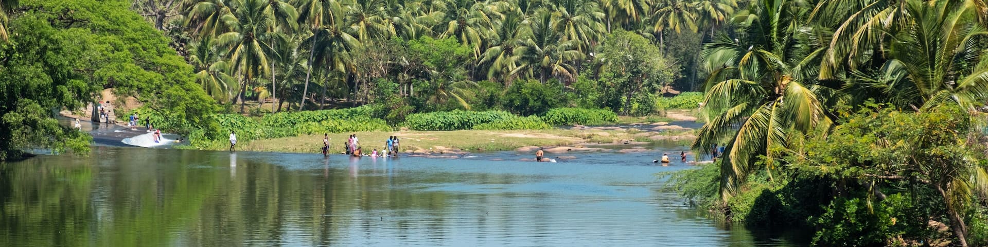 Scene on the river Noyyal, in the Tiruppur district of Tamil Nadu in southern India, with local people bathing and washing clothing at a natural ford